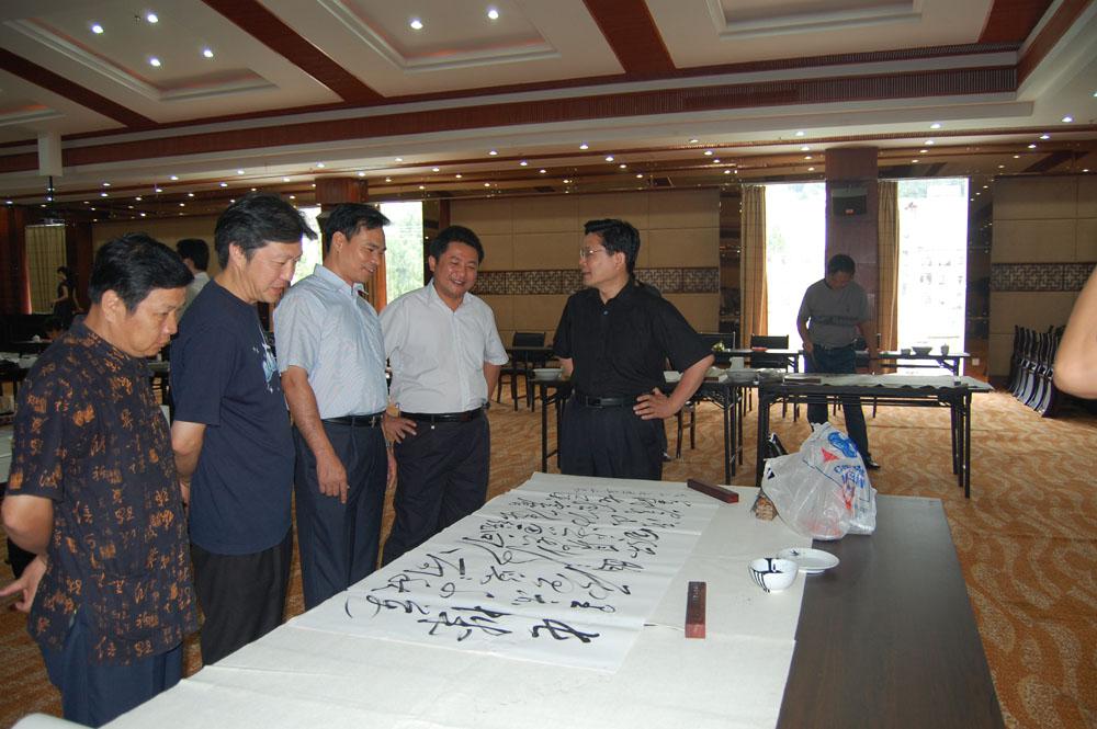 2008年7月27日，汪国真在向泰宁县委书记曾祥辉（中）、常务副县长郑剑波（右二）介绍创作心得。
