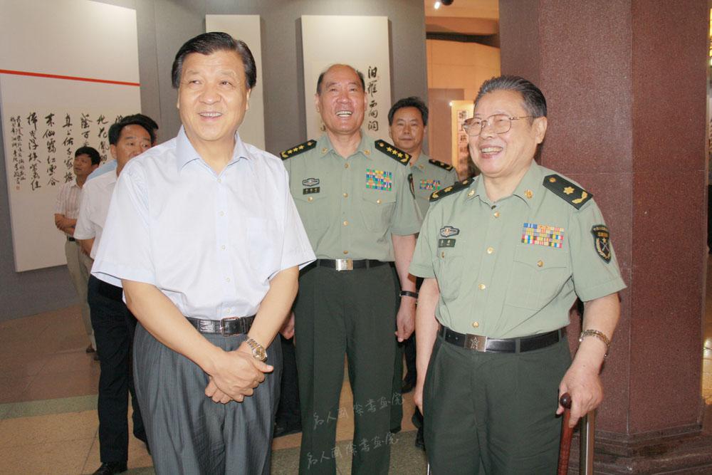  2011年8月25日，刘云山（左）在中央军委委员、总政治部主任李继耐（中）陪同下参观李铎诗词书法展。